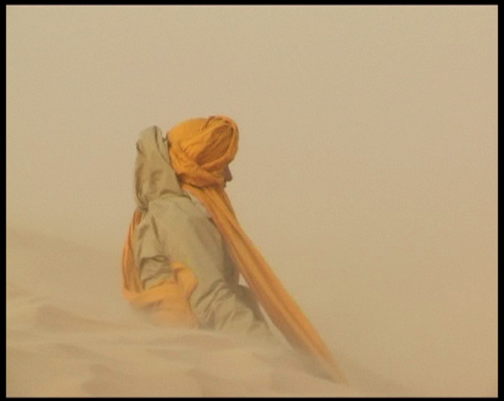 Marie-Anne assise dans le vent du désert tunisien