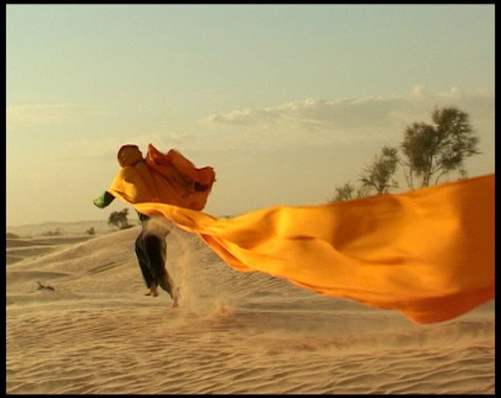 Course avec un chèche et le vent dans le désert tunisien